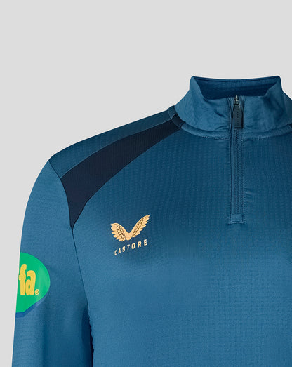 Shoulder close up of blue training top showing Breeden emblem and Castore branding.