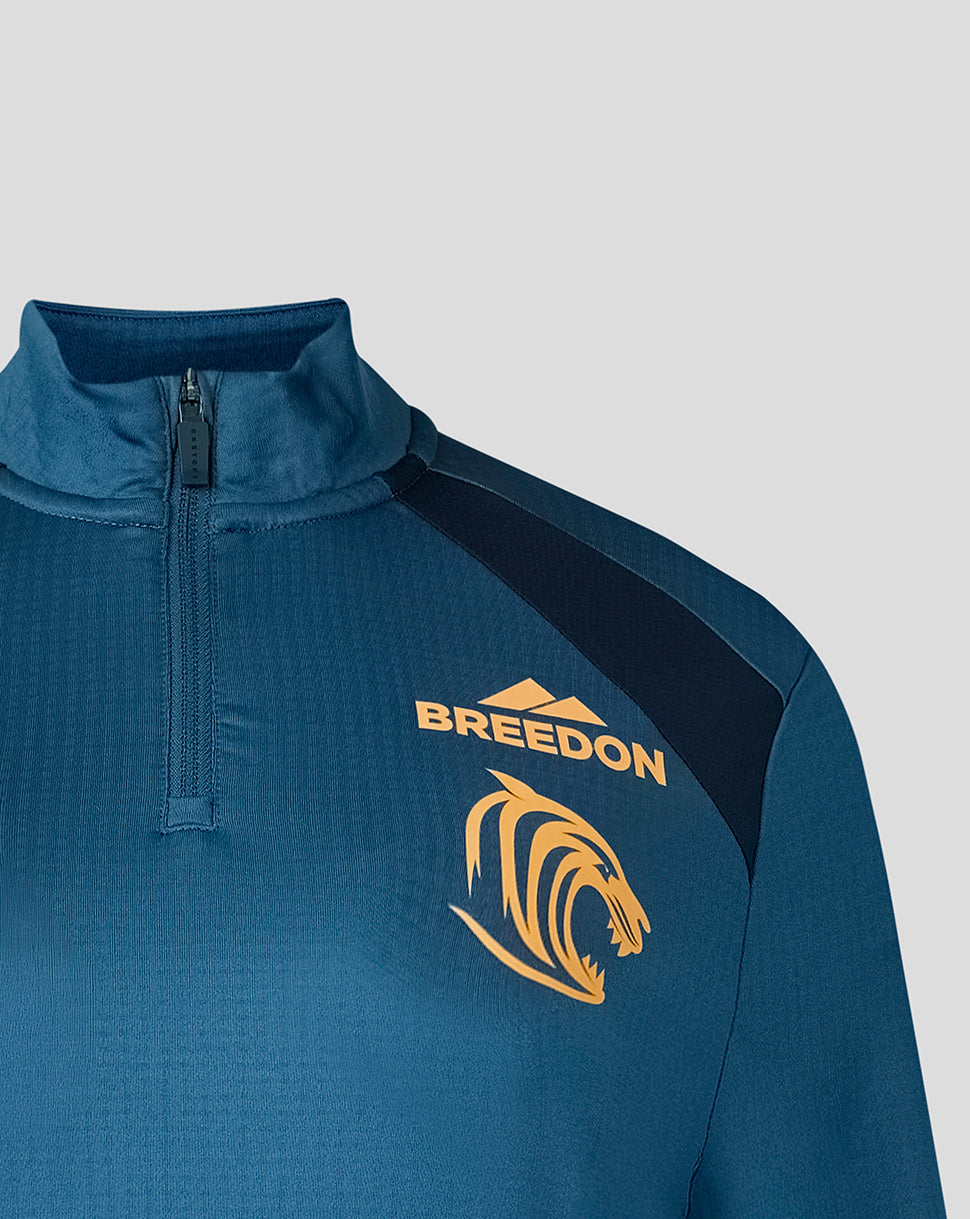 Close up of blue training top with quarter zip and Breeden logo on chest.