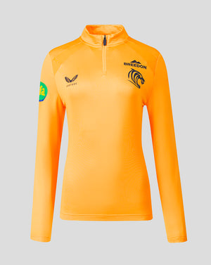 A women's long-sleeve athletic quarter-zip pullover in bright orange, featuring black 'BREEDON' and a lion logo on the left chest, a winged logo with 'CASTORE' on the right chest, and a green circular patch on the right sleeve, shown against a solid gray background.