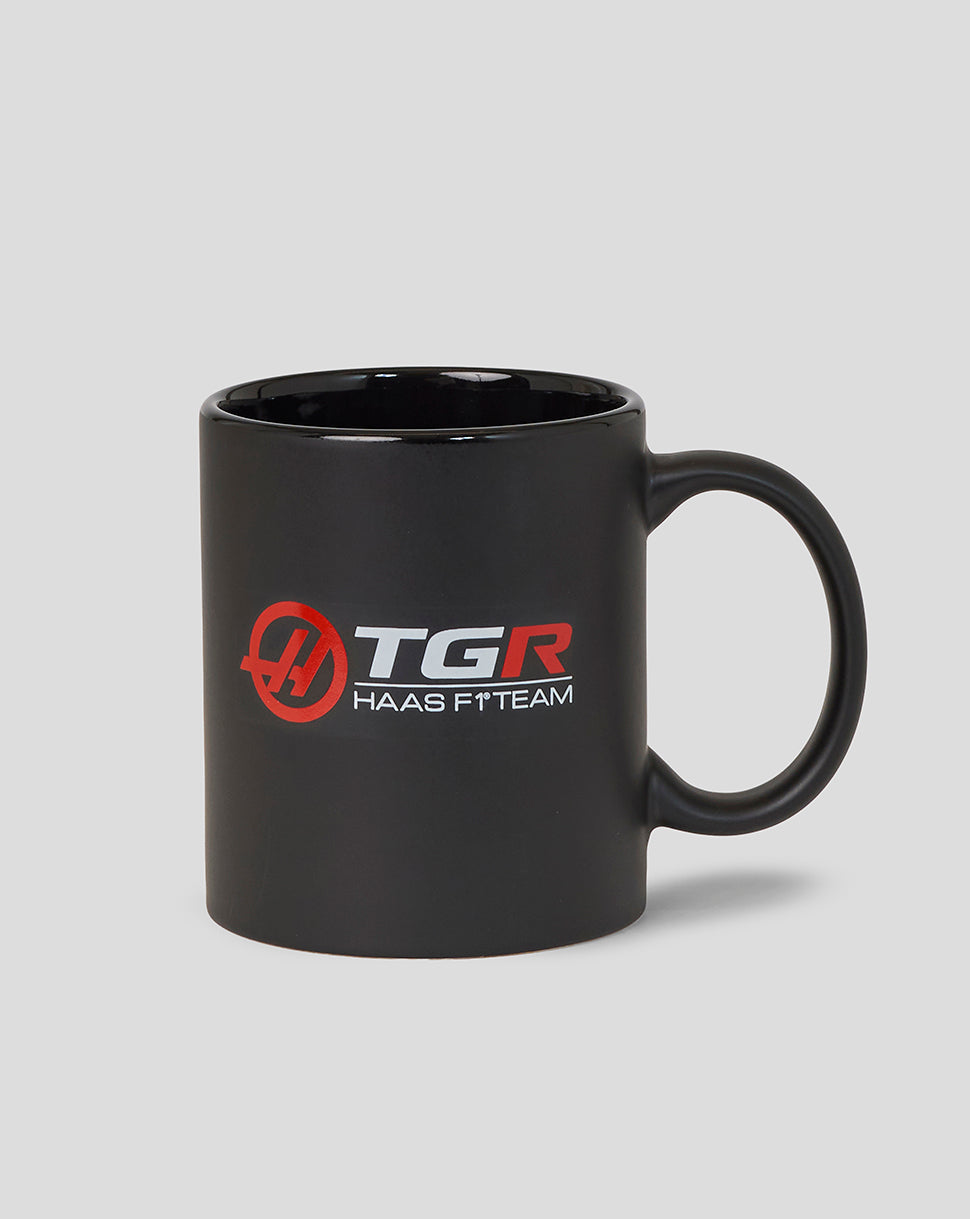 Black mug with TGR Haas F1 Team logo on a gray background