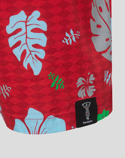 Red fabric with tropical leaf patterns and a brand label on a white background