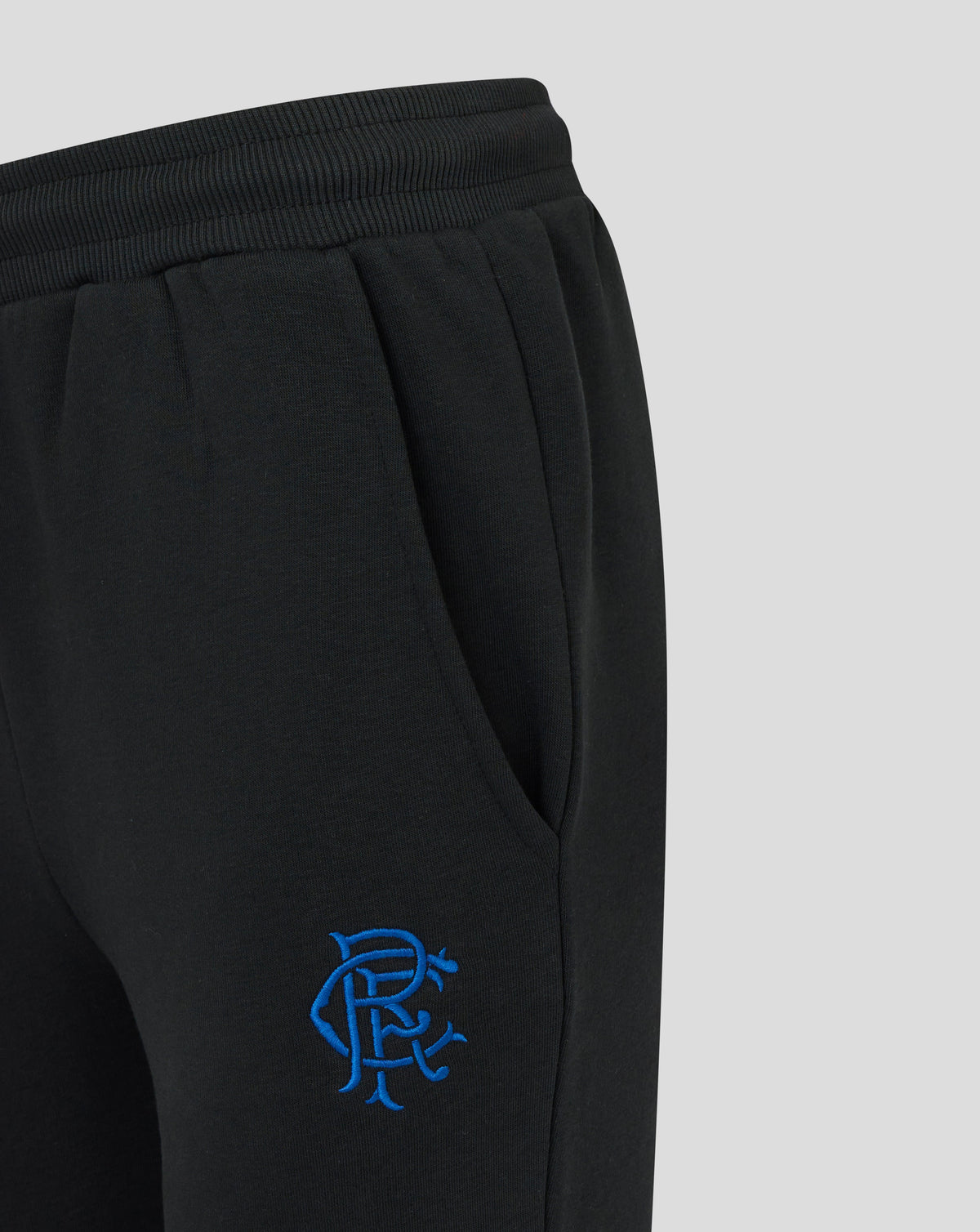 Close up of the black Rangers Core Joggers waistband with ribbed elastic and a blue embroidered emblem on the hip.