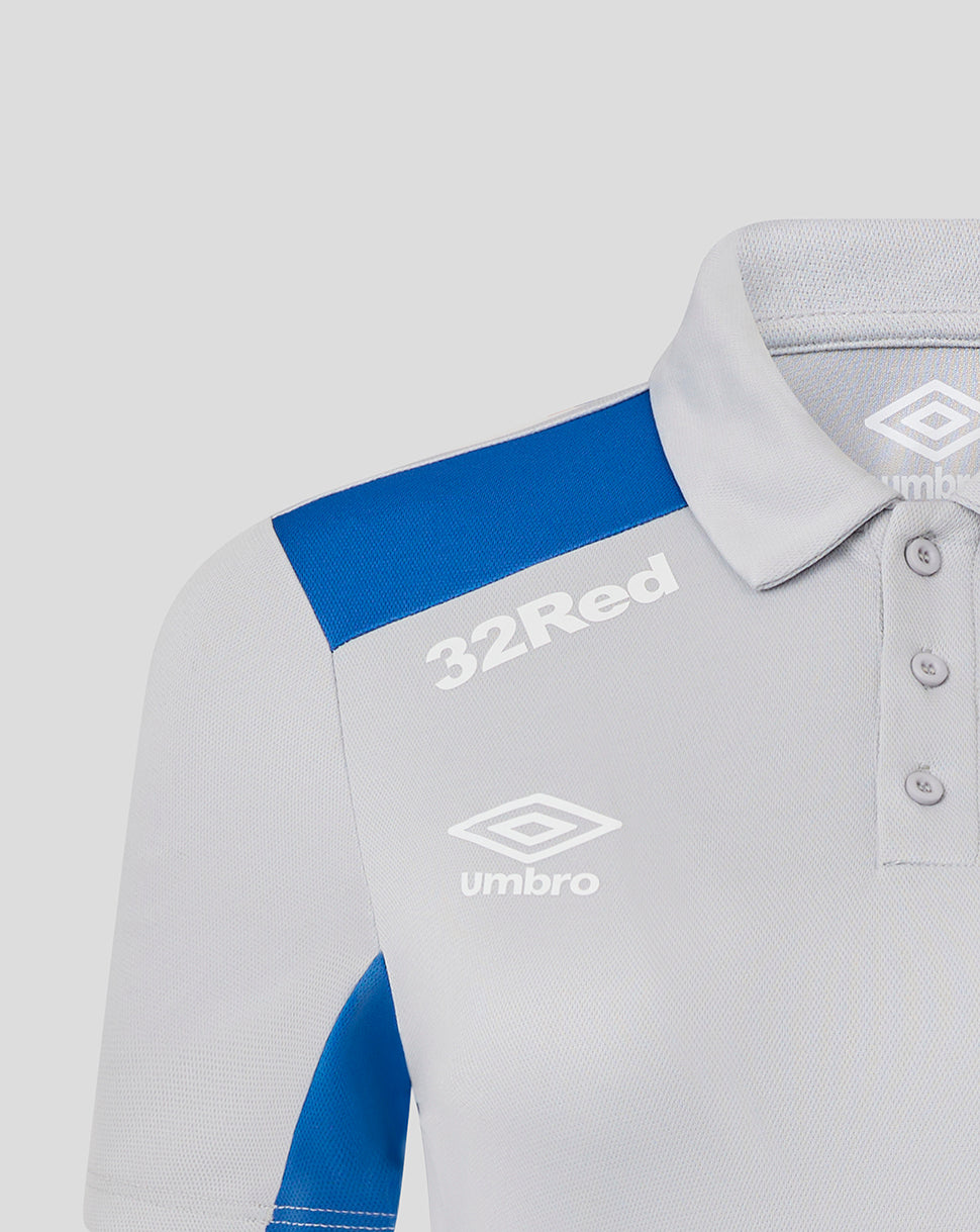 Close-up of Rangers Women's 25/26 Presentation Polo in Microchip gray with blue shoulder panel showing 32Red text and Umbro crest