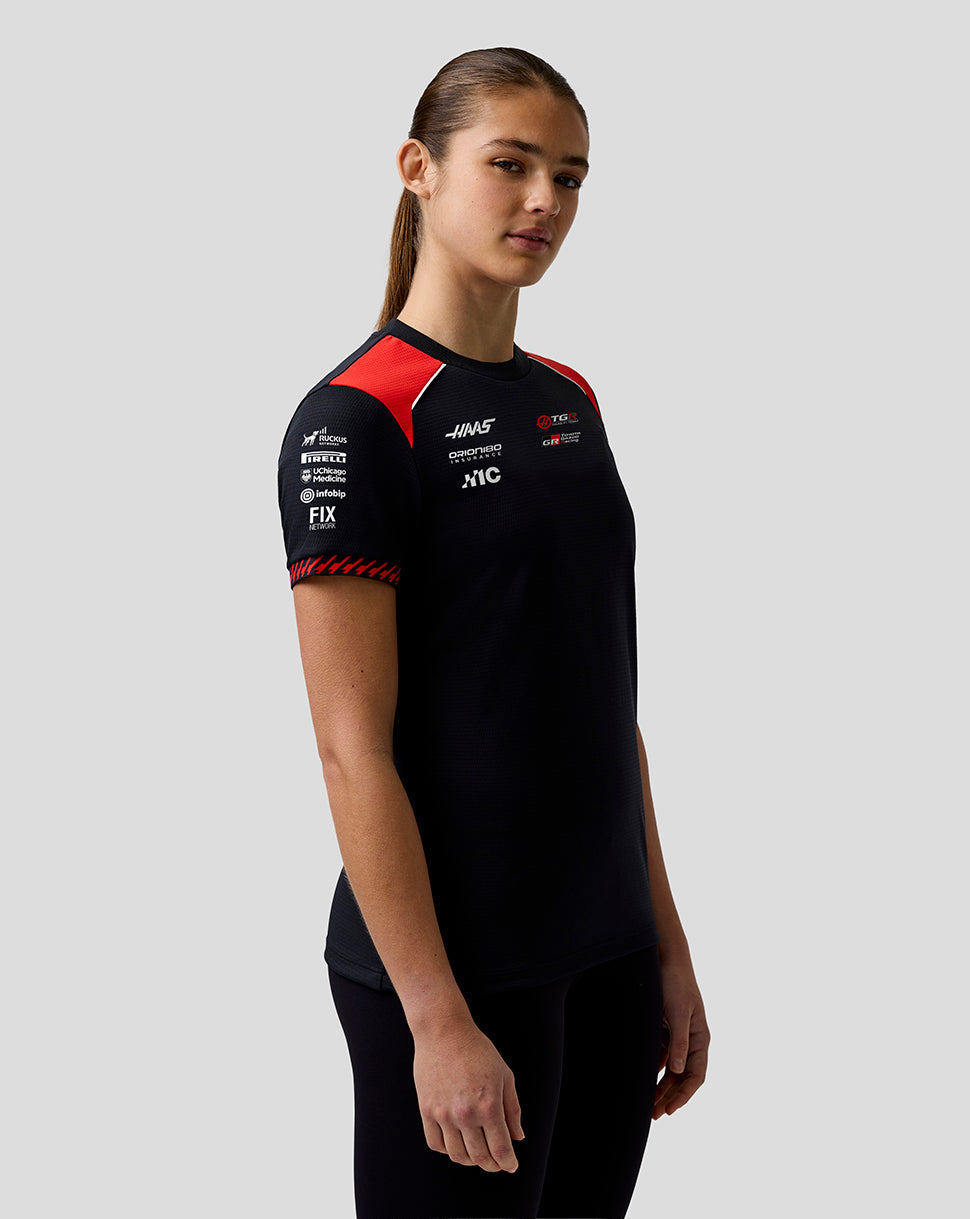 Person wearing a black sports outfit with red accents on a gray background