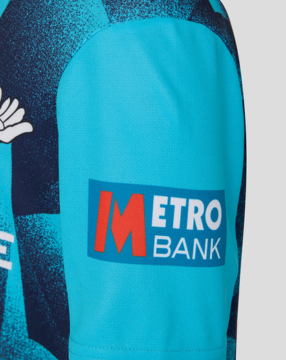 Close-up of a sports jersey with Metro Bank logo on a blue sleeve.