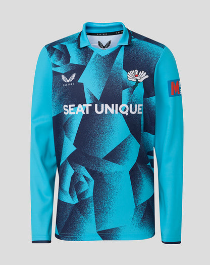 Blue long-sleeve shirt with geometric pattern and visible branding on a gray background