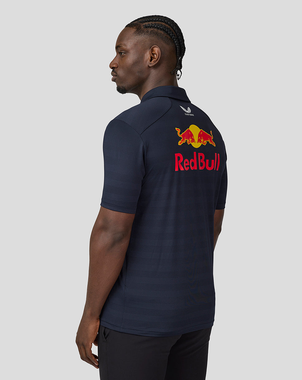 Back view of a man wearing a navy team polo with the Red Bull logo on the upper back and a small Castore emblem at the neck.