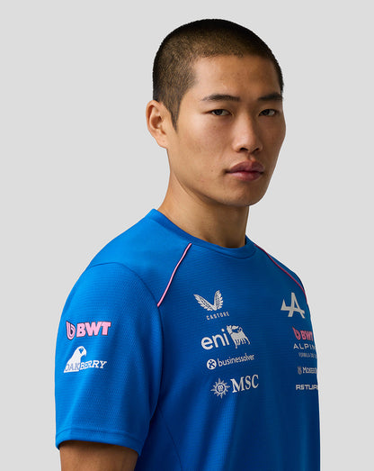 Man wearing a blue sports jersey with various sponsor logos on a gray background