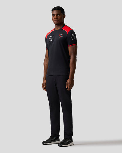 Person wearing a black and red sports outfit on a light gray background