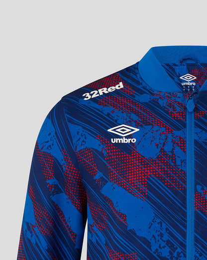 Blue sports jacket with red patterns and Umbro branding on a gray background
