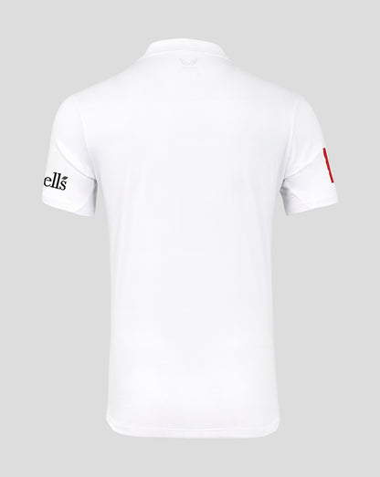 White t-shirt with brand logo on sleeve against a gray background