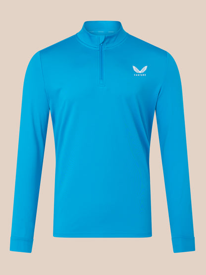 Blue long-sleeve shirt with a brand logo on a beige background