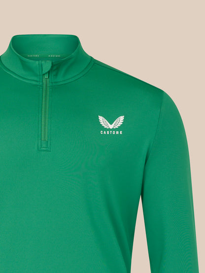 Green long-sleeve shirt with a white logo on a beige background