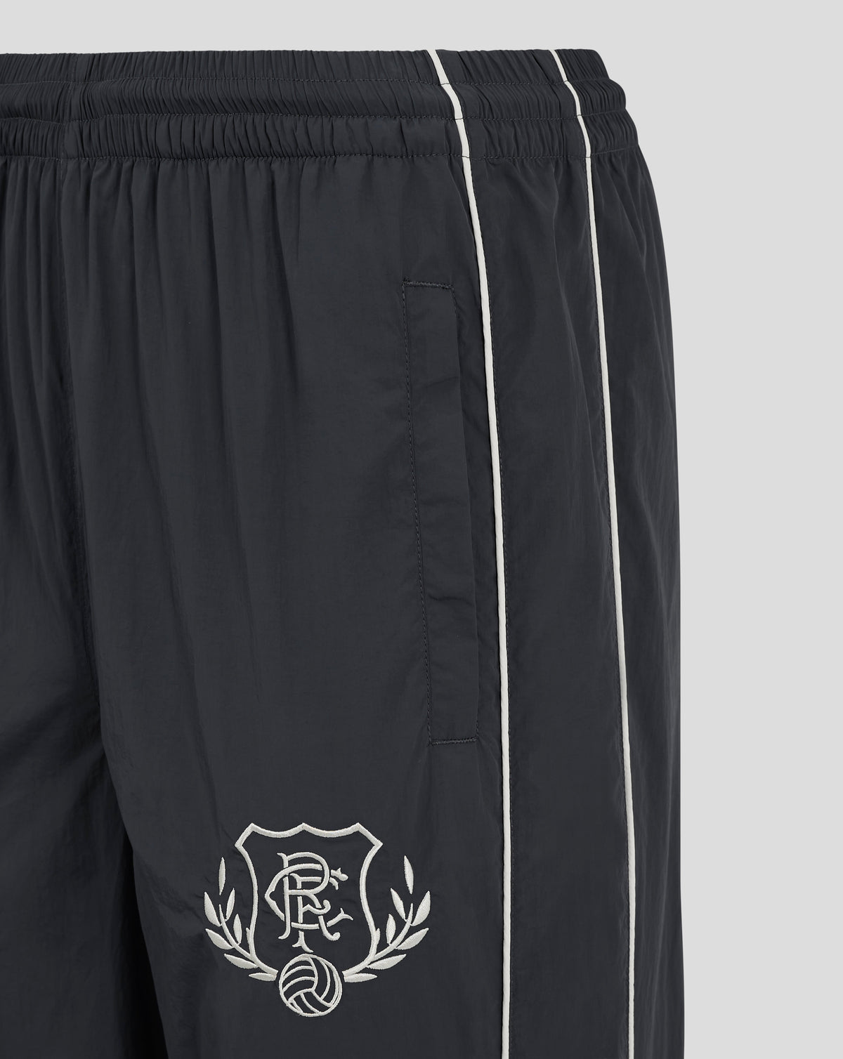 Close up of navy Rangers FC track pants showing elasticated waistband and full length white piping along the legs.