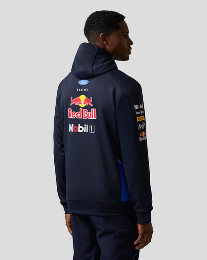 Person wearing a navy hoodie with Red Bull and Mobil 1 logos on the back against a light gray background
