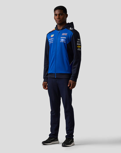 Person wearing a blue and black tracksuit with visible branding on a white background