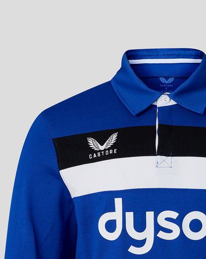 Blue polo shirt with Castore and Dyson logos on a gray background