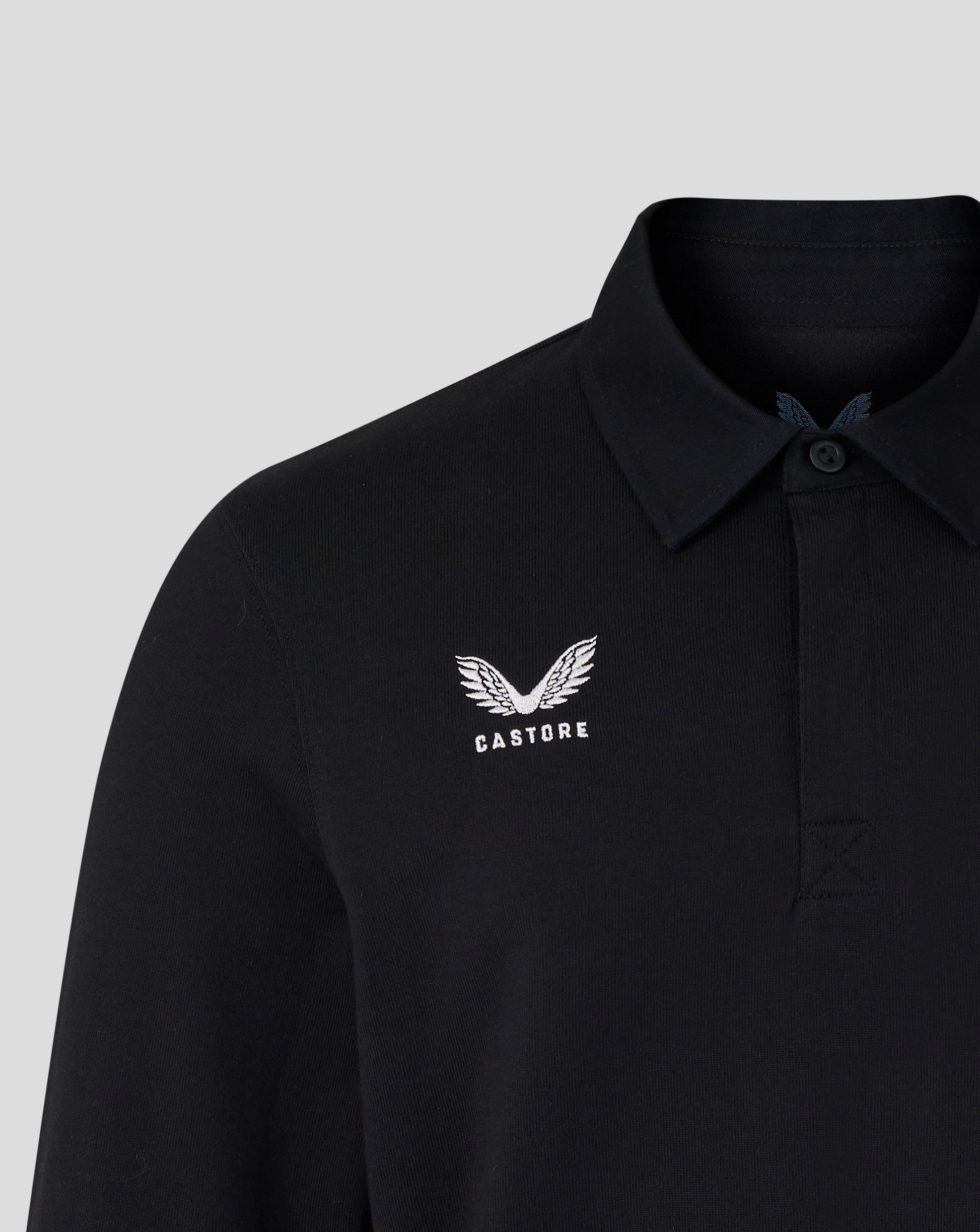 Black polo shirt with white logo on a light gray background