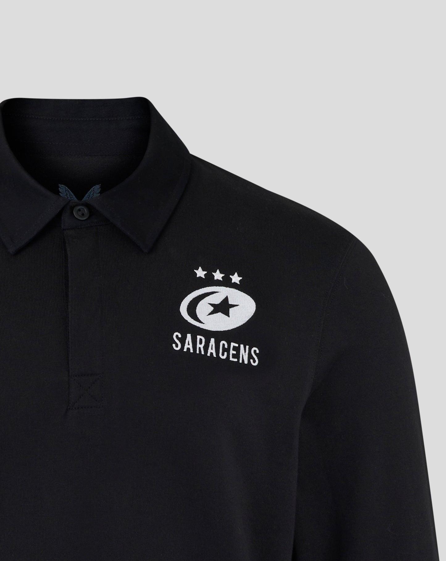 Black polo shirt with Saracens logo on a gray background