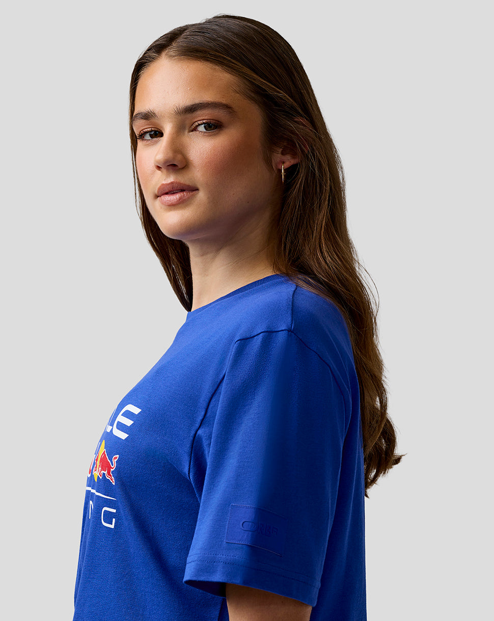 Woman wearing a blue t-shirt with a logo on a gray background