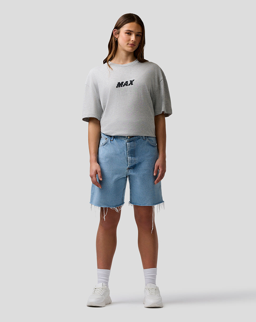 Person wearing a gray t-shirt with 'MAX' text and blue denim shorts on a white background
