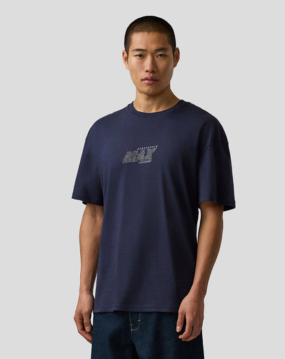 Man wearing a navy blue t-shirt with a logo on a plain background