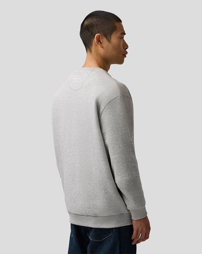 Person wearing a gray sweatshirt against a plain background