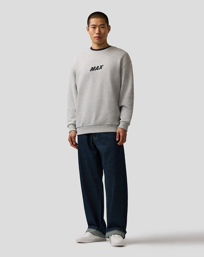 Man wearing a gray sweatshirt with 'MAX' text and dark jeans on a white background