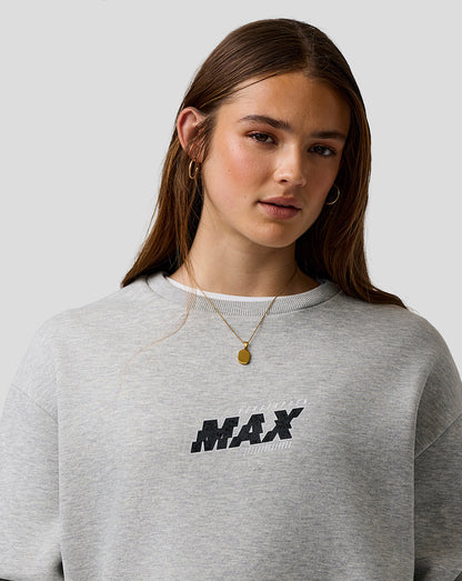 Person wearing a gray sweatshirt with 'MAX' print on a plain background