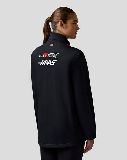 Person wearing a black jacket with Toyota Gazoo Racing logo on the back against a gray background