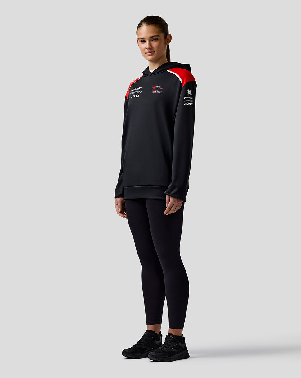 Person wearing a black tracksuit with red accents on a white background