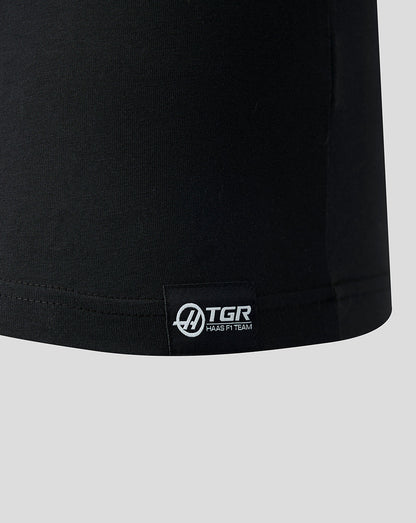 Black t-shirt with a visible brand logo on a light gray background