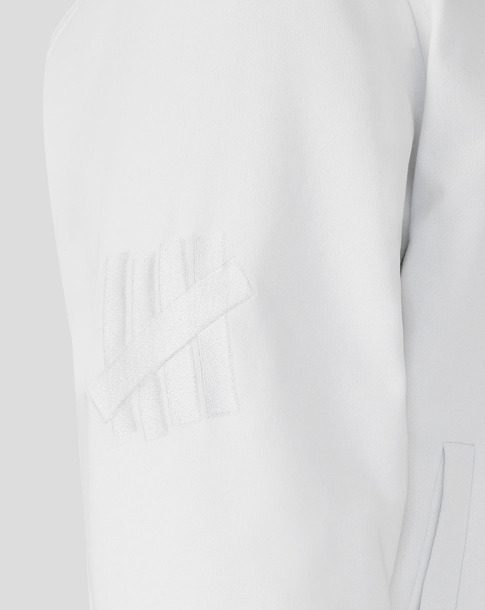 Close-up of a white dress with a subtle pattern on a light gray background