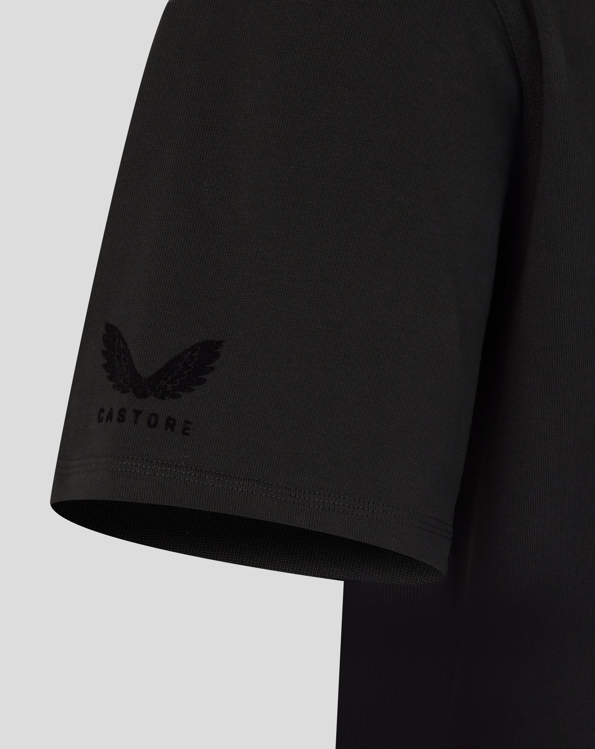 Black t-shirt sleeve with a logo on a light gray background