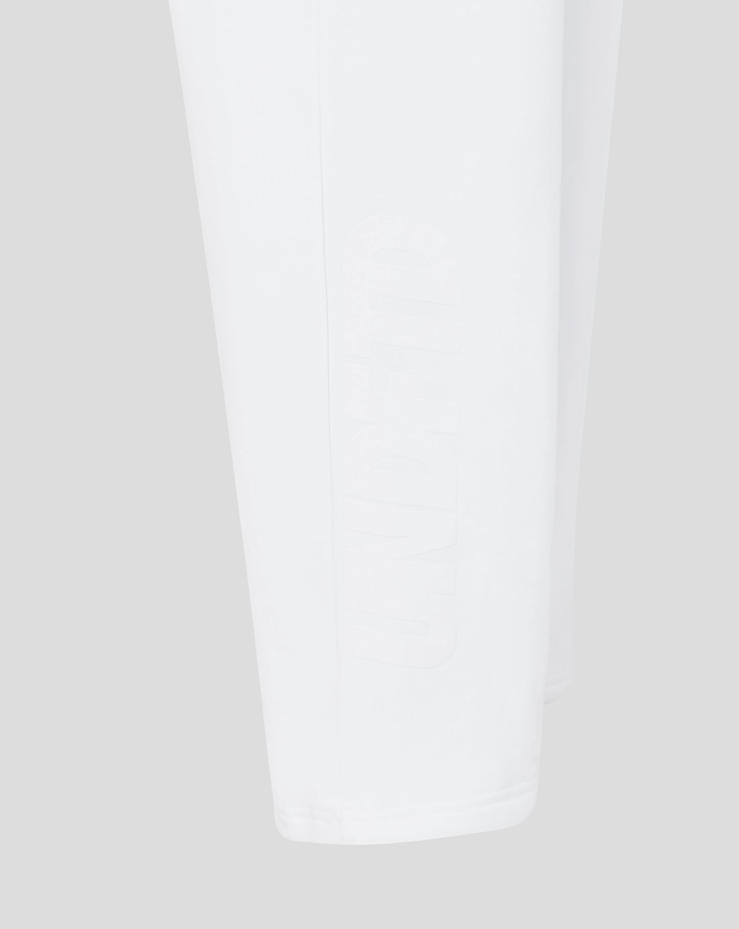 Close-up of white joggers on a light gray background