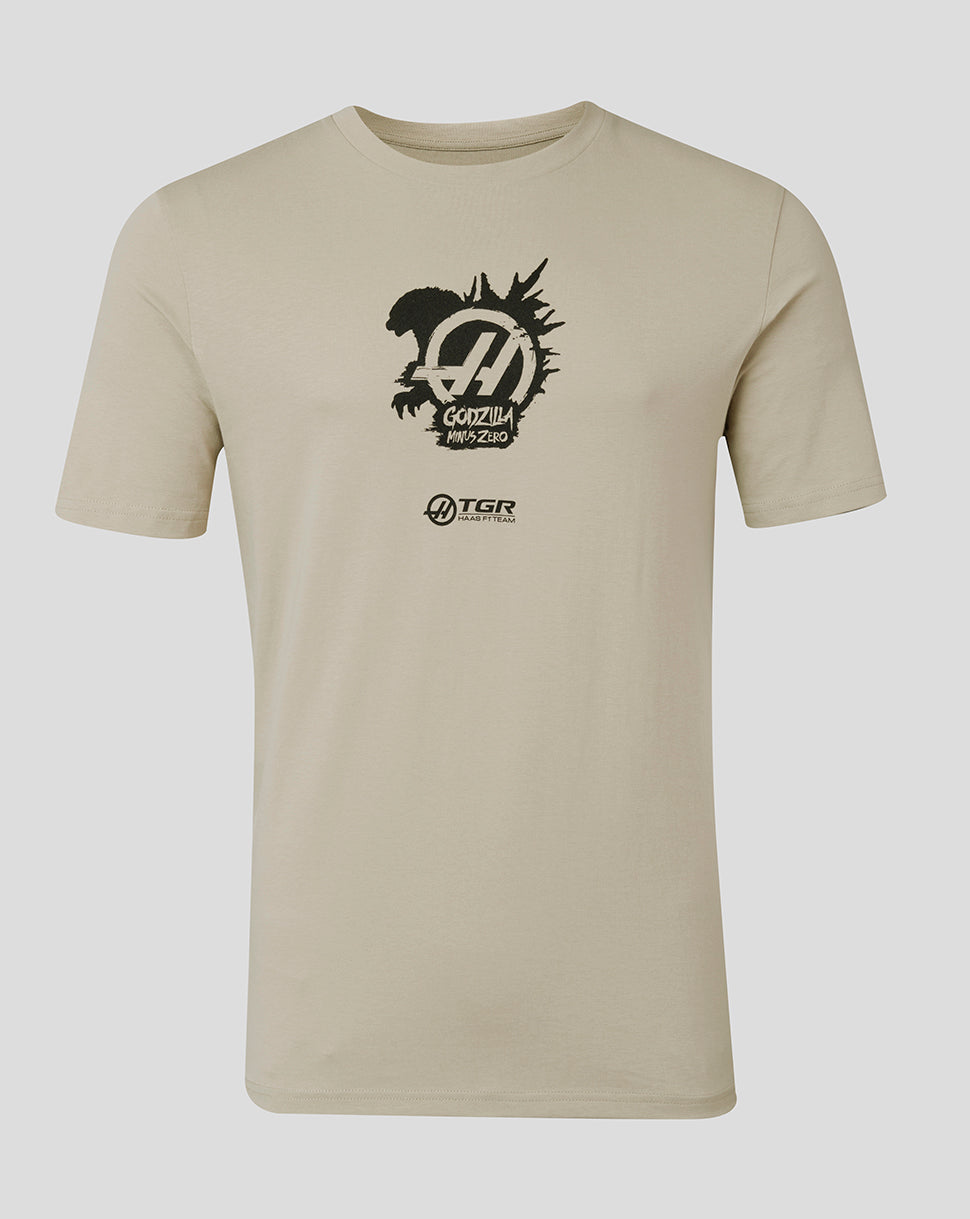 A beige short-sleeve crewneck t-shirt featuring a black graphic print on the chest with a stylized 'H' logo, the text 'GODZILLA MONSTER', and a smaller 'TGR' logo below it, displayed against a neutral gray background.