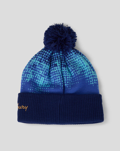 Blue patterned beanie with pom-pom on a light gray background