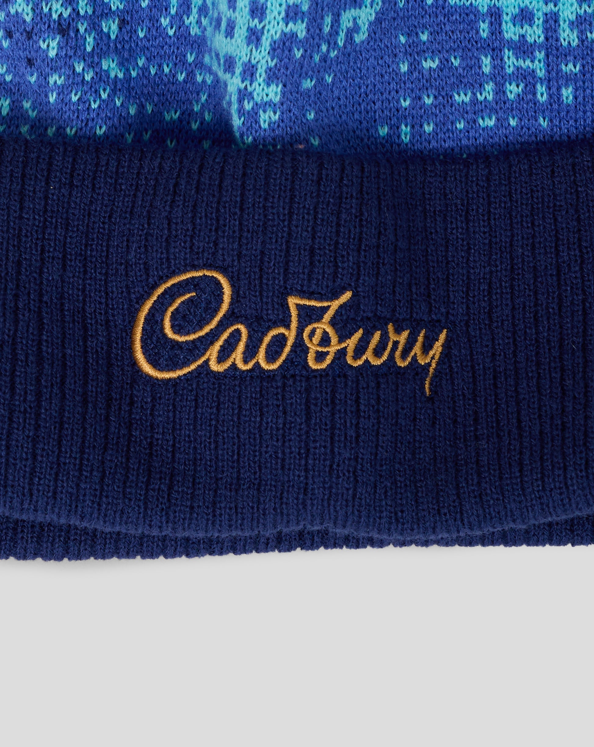 Navy blue fabric with gold 'Cadbury' logo on a white background